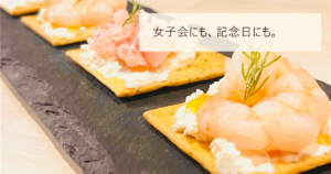 クラッカーに海老とカニをのせた前菜が並ぶ写真と「女子会にも、記念日にも。」の文字