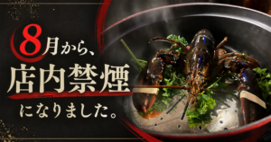 湯気の立つストウブ鍋の活オマール海老と「8月から、店内禁煙になりました。」の文字