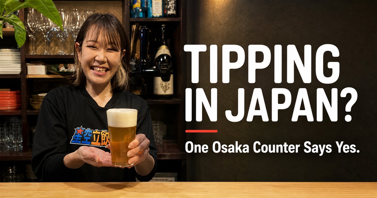 Mizuki-chan smiling and handing a beer across the 6-seat counter at Kaiebi in Shinsaibashi, Osaka