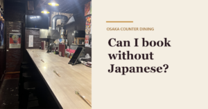 A long wooden counter inside Kaiebi in Shinsaibashi, Osaka, with warm pendant lights, next to the text Can I book without Japanese?