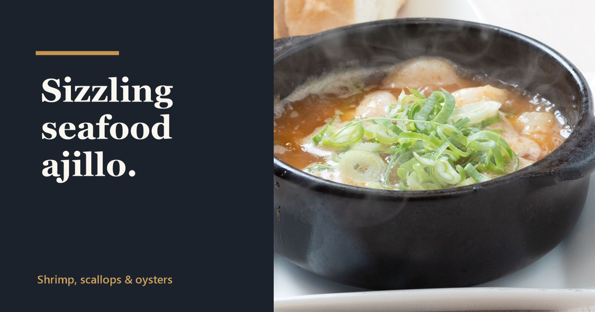 Sizzling seafood ajillo with shrimp and scallops in a black pot, served with bread at Kaiebi, a 6-seat seafood counter in Shinsaibashi, Osaka