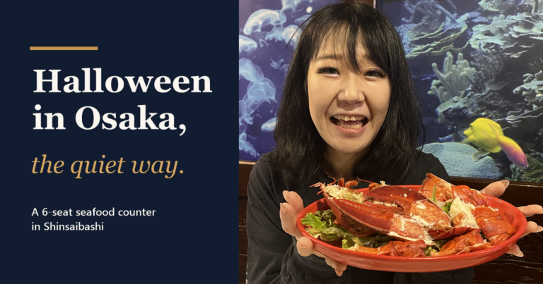 Mizuki-chan smiling and holding a red plate of lobster at our Shinsaibashi seafood counter, with the words Halloween in Osaka, the quiet way.