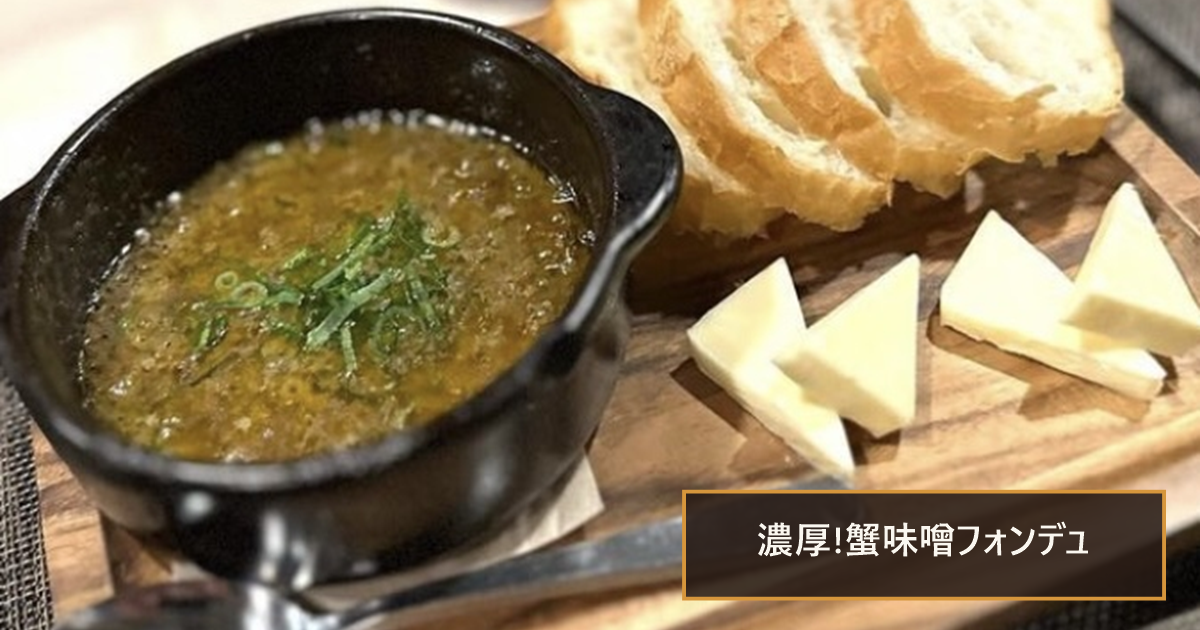 小鍋の蟹味噌ソースと、木のボードにのったパンとチーズ。「濃厚!蟹味噌フォンデュ」の文字