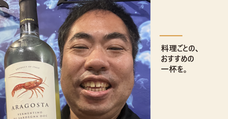 ロブスターの絵が描かれた白ワインのボトルを手に笑う店主。「料理ごとの、おすすめの一杯を。」の文字