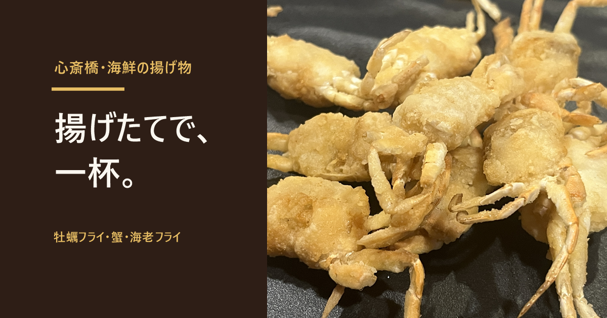 心斎橋「貝と海老そして蟹」のクリスピークラブ。小さな蟹を丸ごと揚げた一皿と「揚げたてで、一杯。」の文字